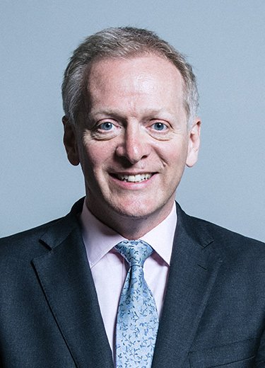 A professional head and shoulders image of Dr Phillip Lee wearing a navy suit and light blue tie.